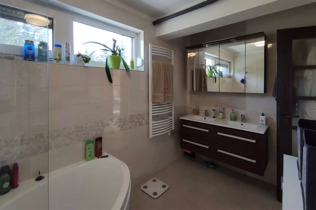 Az emeleti fürdőszoba szaniterei: dupla mosdó, Geberit WC és Ravak sarokkád, melyben a kádparavánnak köszönhetően zuhanyozni is lehet
