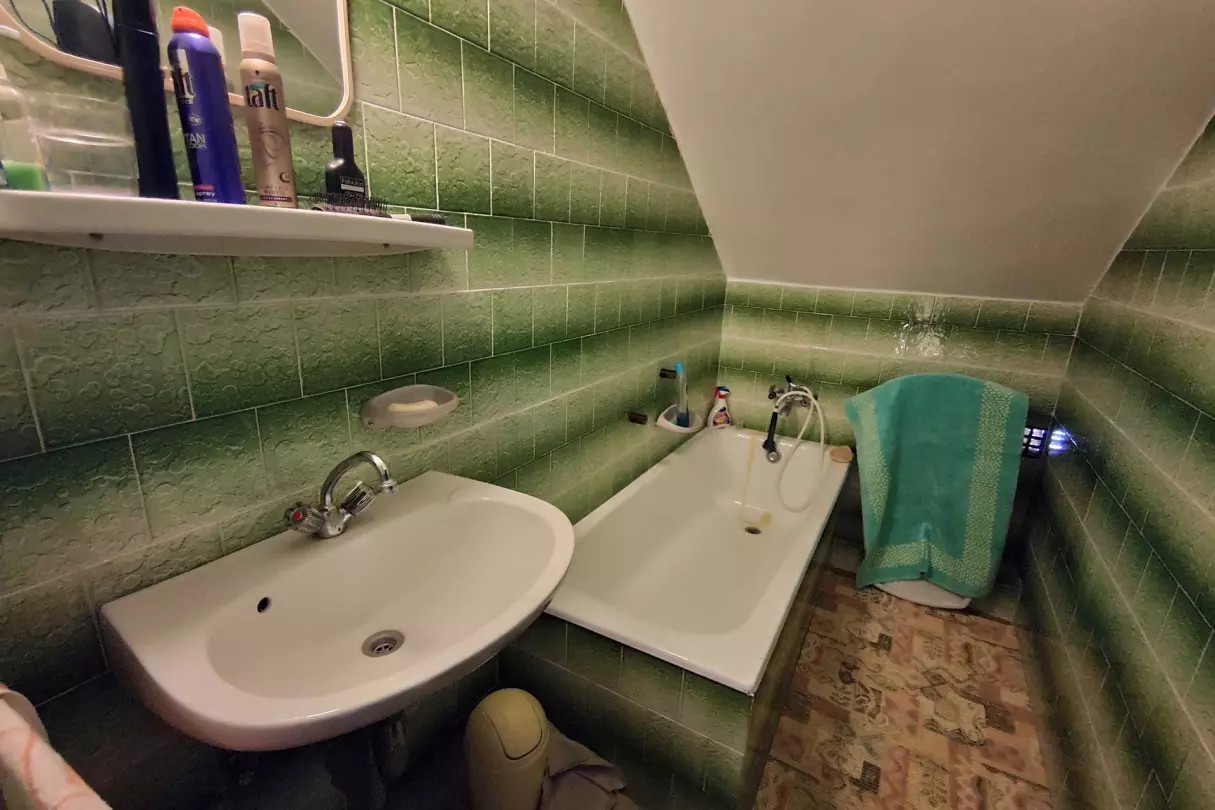 A kép, a tetőtéri fürdőszobát (kád,- mosdó) ábrázolja