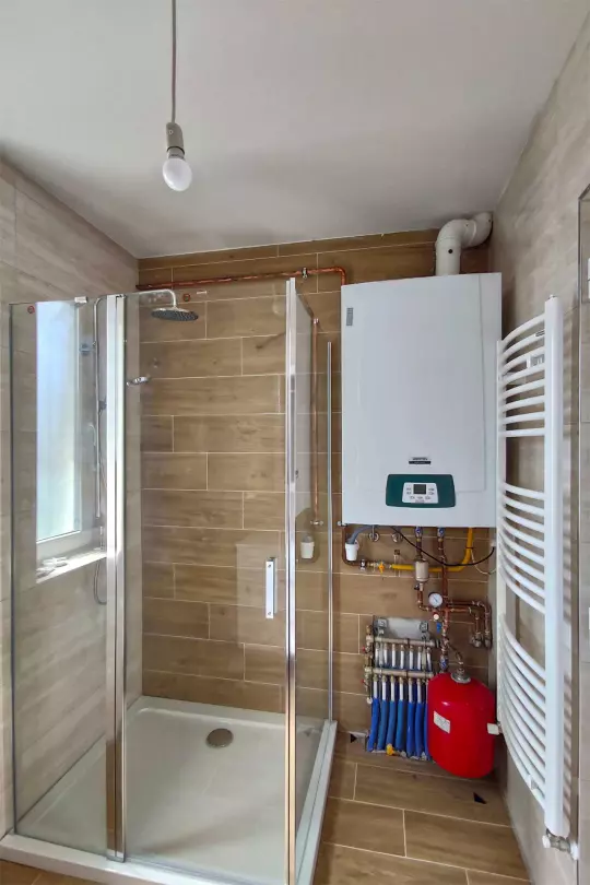 A képen, az emeleti fürdőszoba (zuhanyozó,- mosdó) látható a turbó ventillációs gázkazánnal