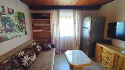 A vendégház 17,92 m2-es lakószobájában kapott helyet a beépített konyha és a lépcsőfeljáró. 